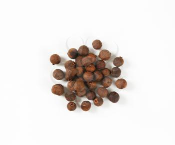 pile of allspice berries on white background