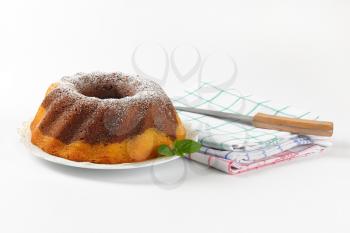 marble bundt cake, kitchen knife and checkered dish towels on white background