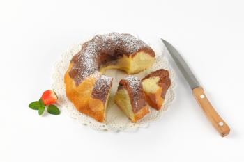 sliced marble bundt cake on white lace and kitchen knife