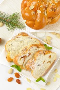 whole and sliced sweet braided bread with almonds and raisins
