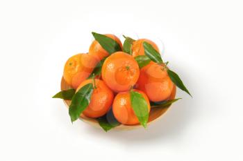 plate of ripe tangerines on white background
