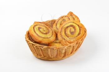 basket bowl of sweet cinnamon rolls on white background