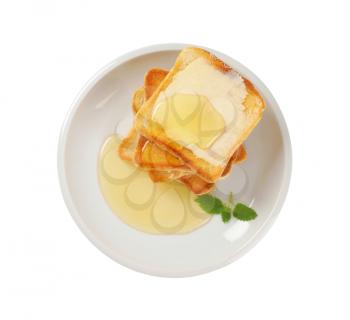 stack of toasted bread slices with butter and honey