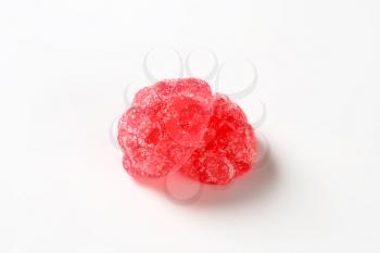 two red jelly candies coated with sugar on white background