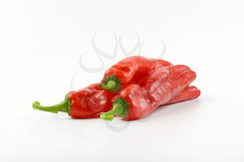 four red peppers on white background