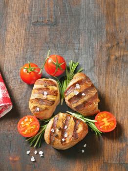 grilled pork medallions on wooden cutting board
