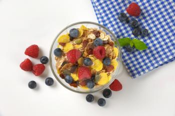 bowl of mixed breakfast cereals with fresh raspberries and blueberries