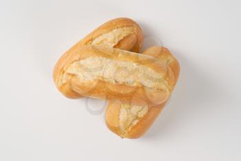 three freshly baked mini baguettes on white background