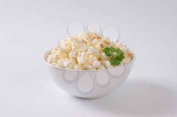 bowl of fresh popcorn on off-white background with shadows