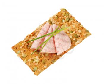 pumpkin seed cracker with thin slices of soft sausage
