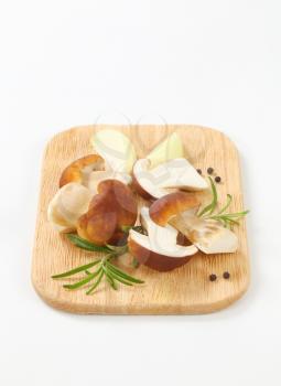 boletus mushrooms with spice on wooden cutting board