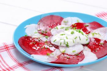 plate of thin beetroot and white radish slices with yogurt - close up