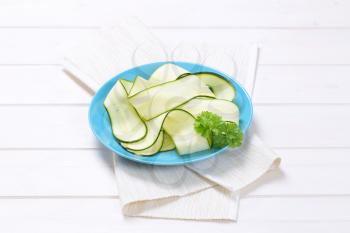 plate of raw zucchini strips on white place mat