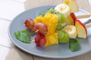 fresh fruit skewers on grey plate - close up