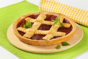 strawberry jam tart with lattice on wooden cutting board