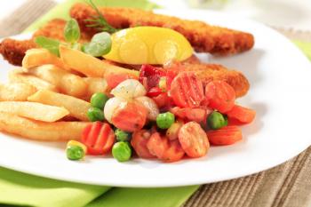 Fried fish served with French fries and mixed vegetables