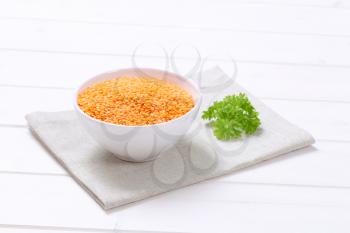bowl of peeled red lentils on beige place mat