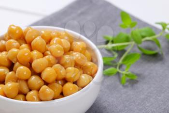 bowl of cooked chickpeas on grey place mat - close up
