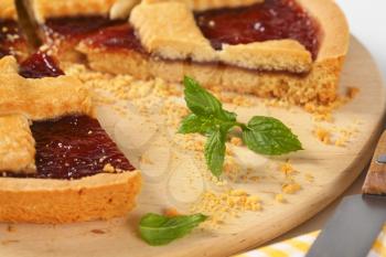 detail of sliced sliced strawberry jam tart with lattice on top