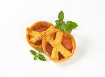small apricot jam tarts on white background