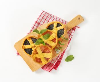 apricot and plum jam tarts on wooden cutting board