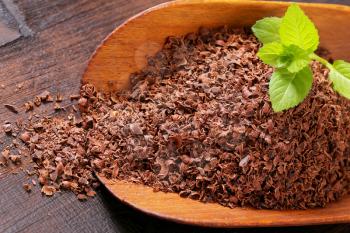 Grated chocolate on wooden scoop