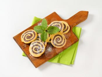 sweet chocolate rolls on wooden cutting board