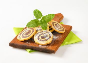 sweet chocolate rolls on wooden cutting board