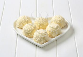 Coconut snowball truffles on heart-shaped plate