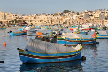 Traditional colorful fishing boats Luzzu moored at Marsaxlokk (Marsascala) Harbor, Malta