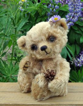Handmade, the sewed toy: teddy-bear Lucky on a little board among flowers
