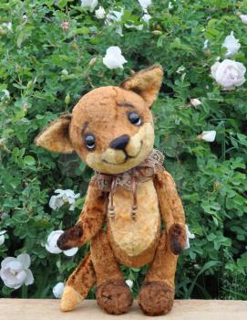 Ron fox cub on a board among flowers. Handmade, the sewed plush toy