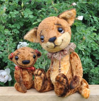 Teddy bear and fox cub on a board among flowers. Handmade, the sewed plush toys