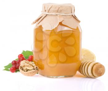 glass jar full of honey and fruit isolated on white background