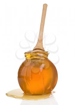 glass jar full of honey and stick isolated on white background