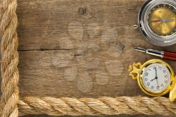 ship ropes and compass with pen on old vintage wooden background