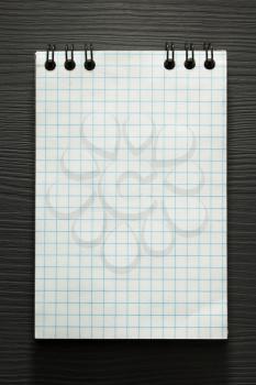 checked notebook  on wooden background