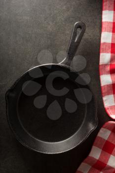 frying pan and napkin on black background