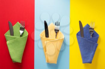 knife and fork at napkin at colorful background
