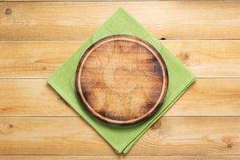 pizza cutting board and naplin at rustic wooden plank background, top view