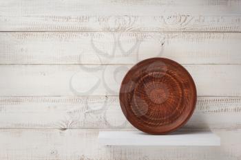 plate at shelf on white wooden plank background