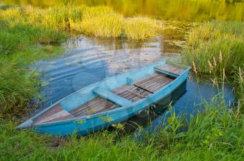 Boat in a grass. A blue boat in a green creek.
