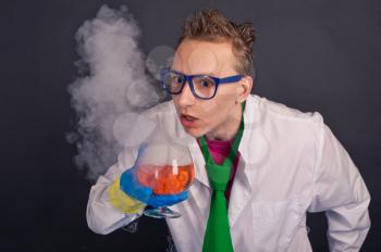 The scientist holds a soaring glass with liquid.
