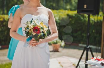 The girl in a wedding dress with a bunch of flowers.