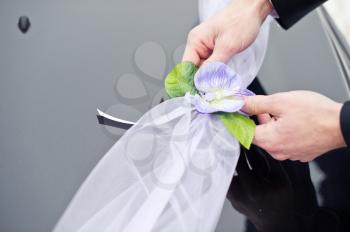 Process of an ornament of the car by a tape with flowers.