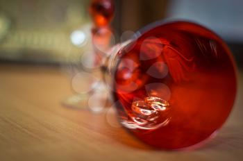 Beautiful red glass with wedding rings lying in it.