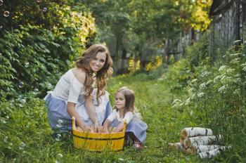 Daughter with mother washing clothes in nature.