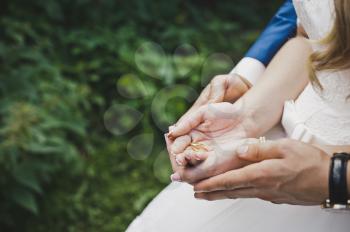 The groom embraces the brides palms with rings.