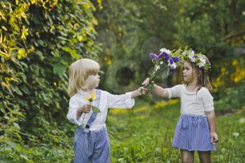 Children playing with flowers in nature.