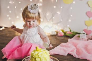 Little girl sitting in front of a sweet cake.